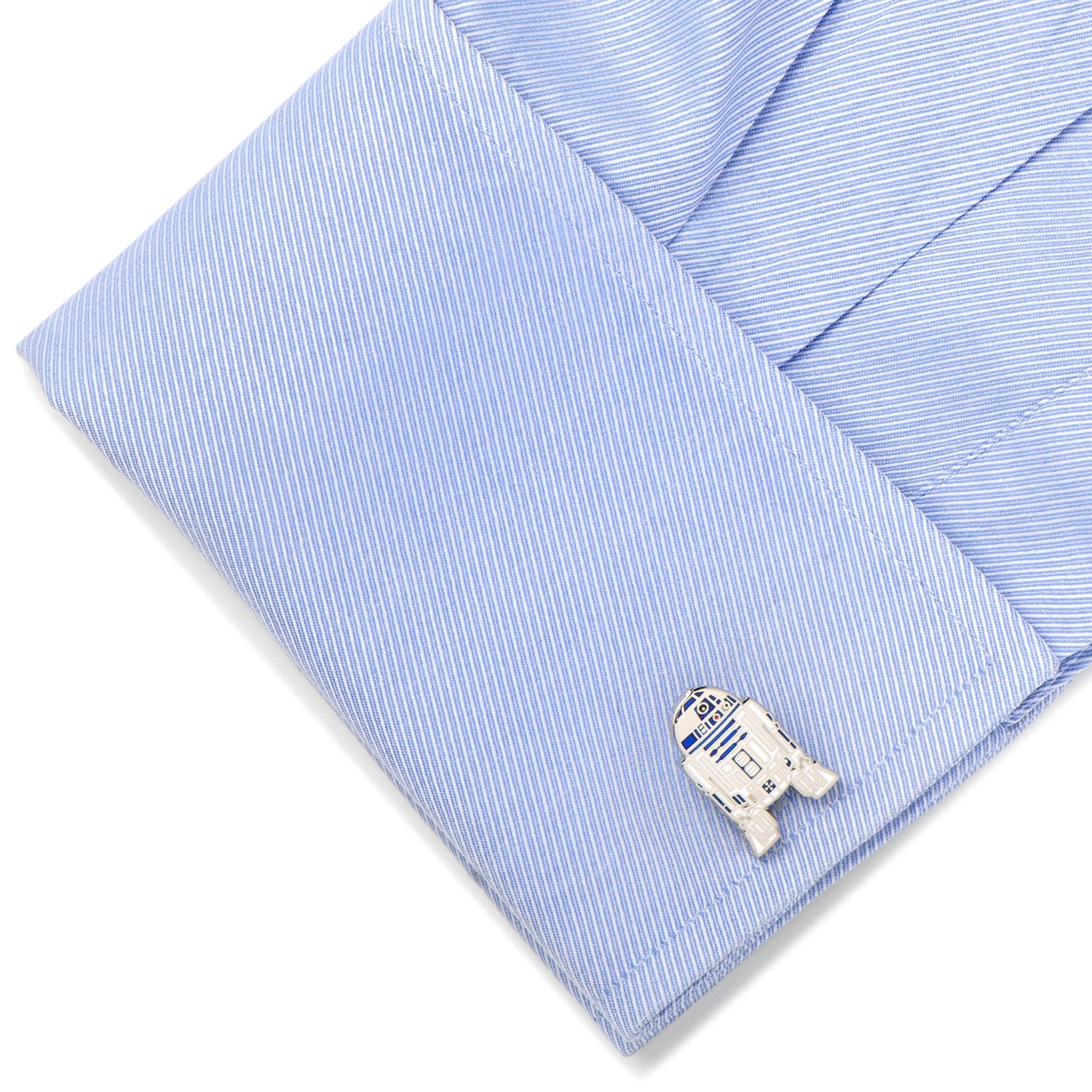Cufflink shaped like R2-D2 from Star Wars on a light blue striped shirt.