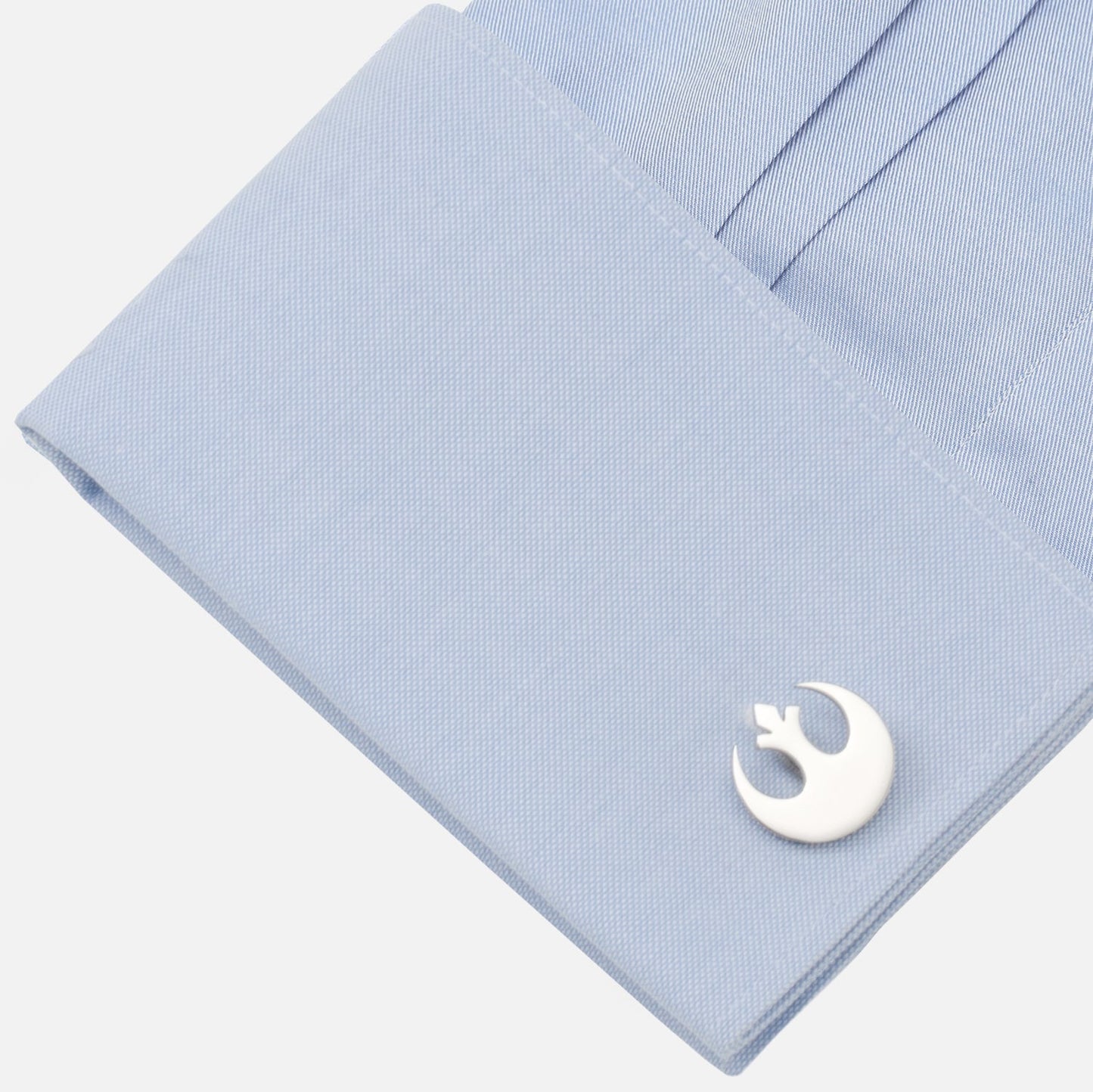 Cufflink with a logo on a light blue shirt