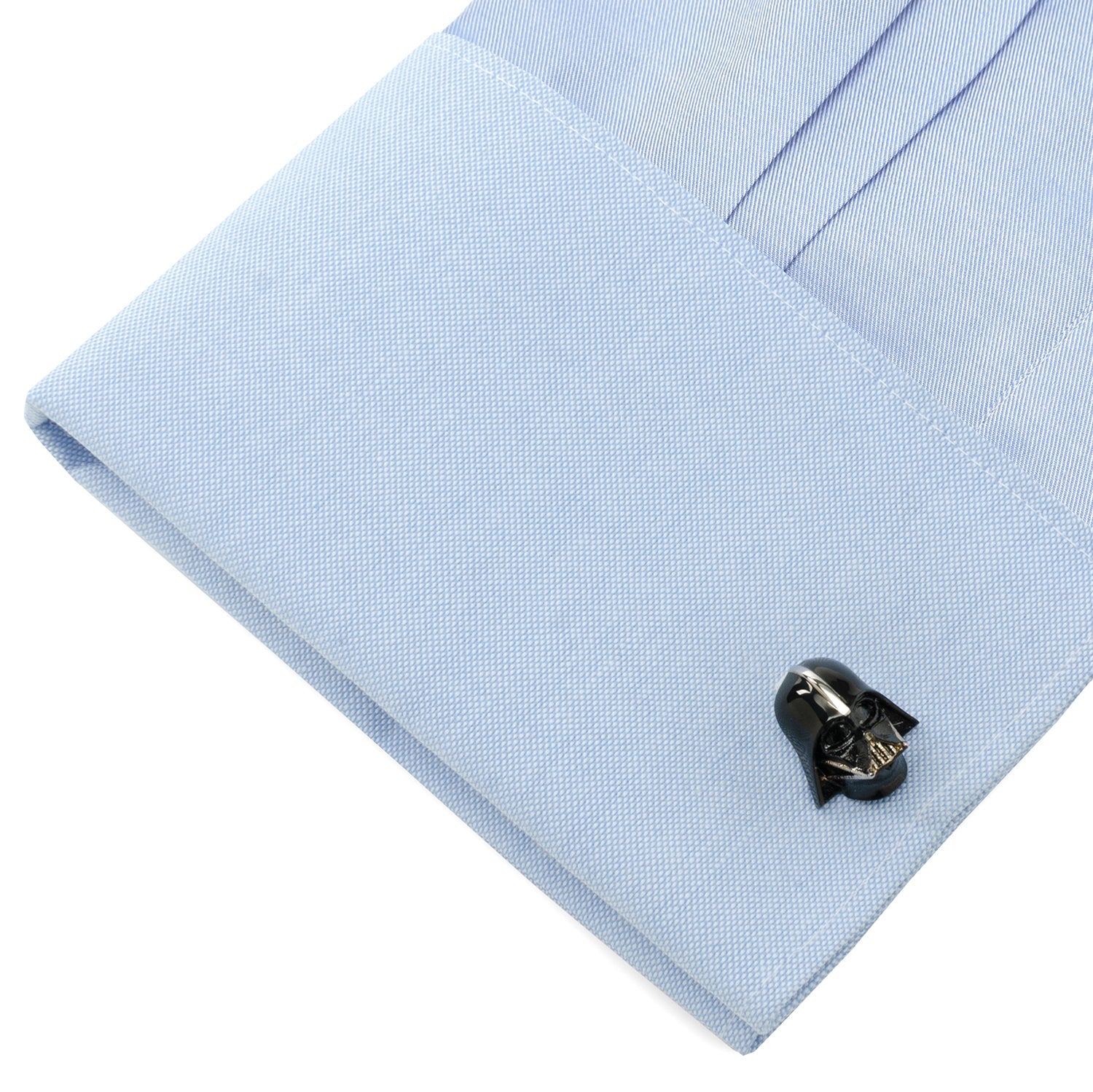 Black cufflink on a light blue dress shirt