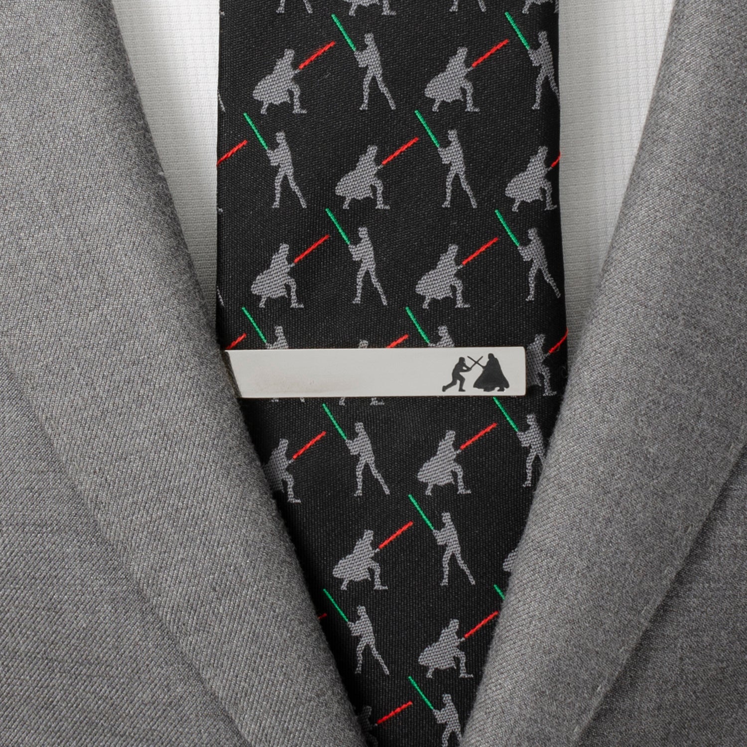 Black tie with light saber pattern and silver tie clip on a gray suit jacket.