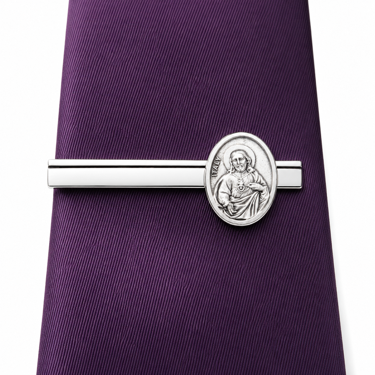 Silver tie clip with a religious design on a purple tie Detailed Sacred Heart medallion on polished silver Christian tie bar