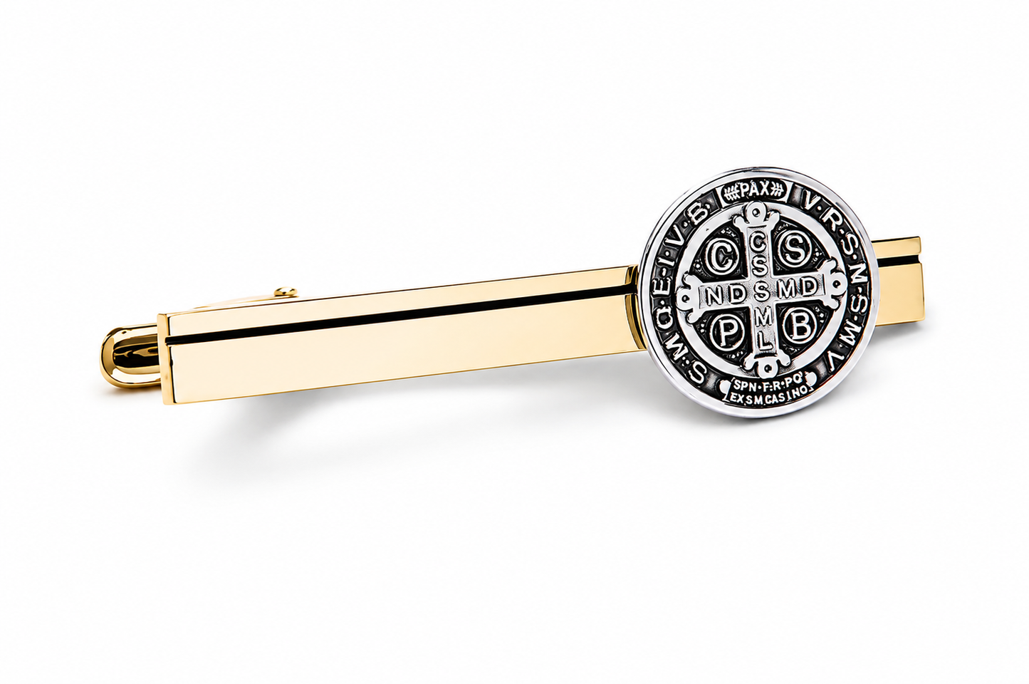 A gold tie clip featuring a circular silver-toned Saint Benedict medal charm, displayed on a clean white background.