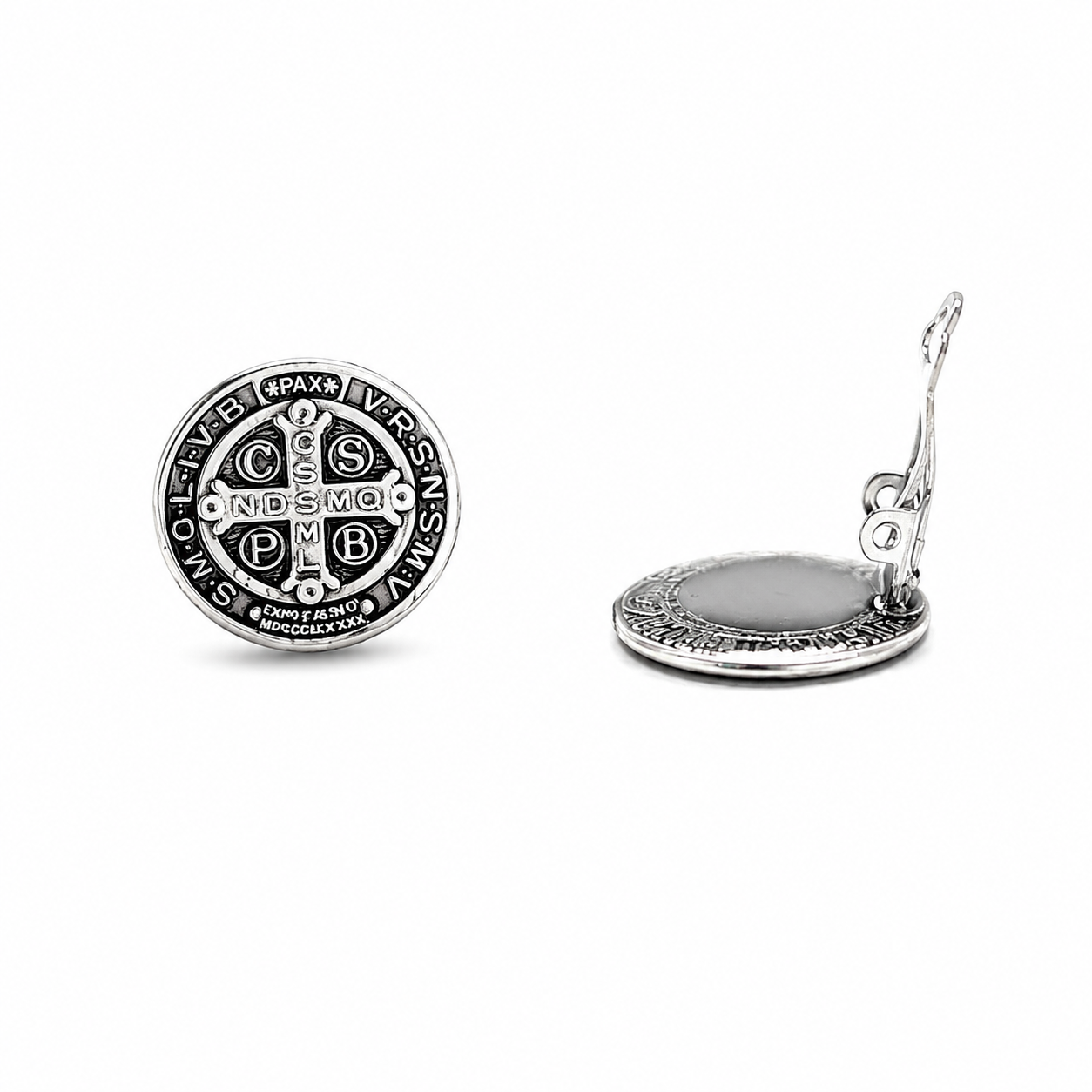 Close-up of silver Saint Benedict medal clip-on earrings with intricate Catholic engraving and polished finish.