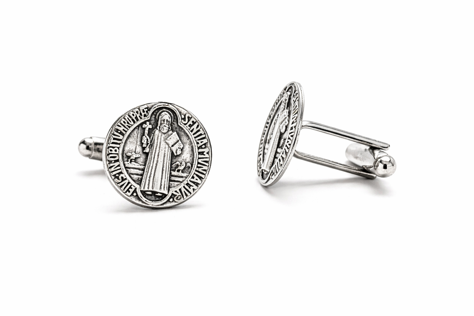 Silver cufflinks with religious design on a white background