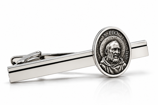 A silver-toned tie clip featuring an oval Saint Pio of Pietra medallion, displayed on a clean white background with a soft reflection.