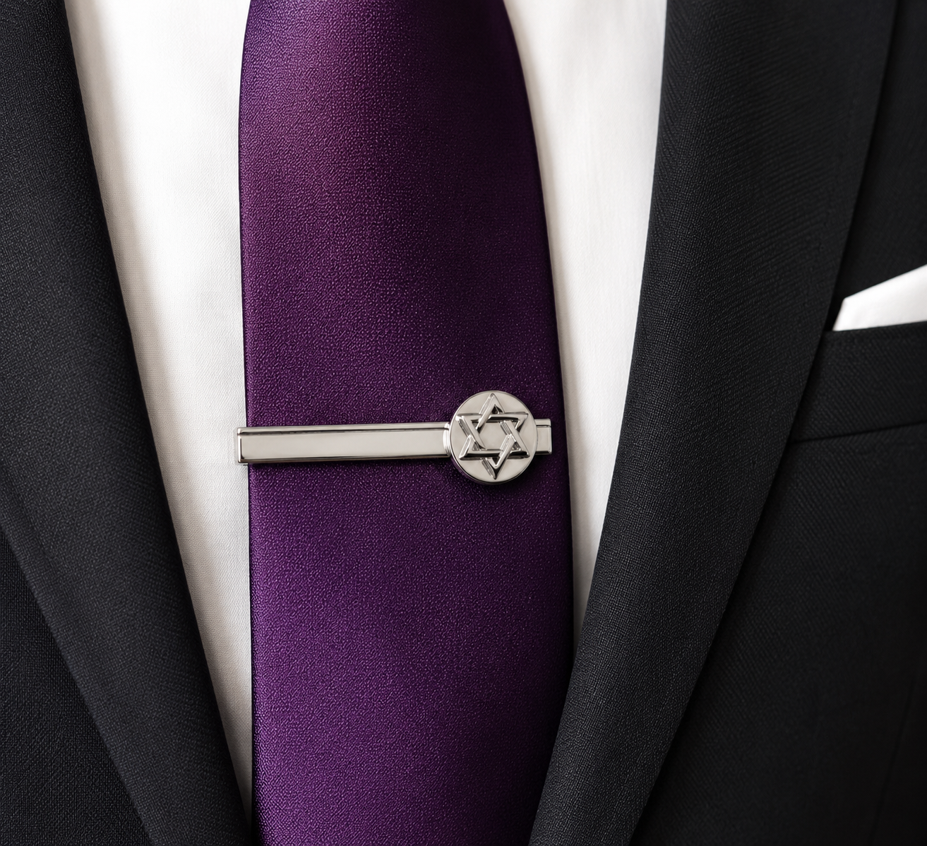 Purple tie with a silver tie clip featuring a Star of David on a black suit jacket.