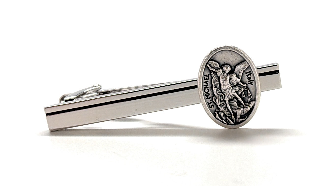 Silver Saint Michael tie clip for men featuring archangel medal on polished silver tie bar Silver tie clip with emblem on a white background