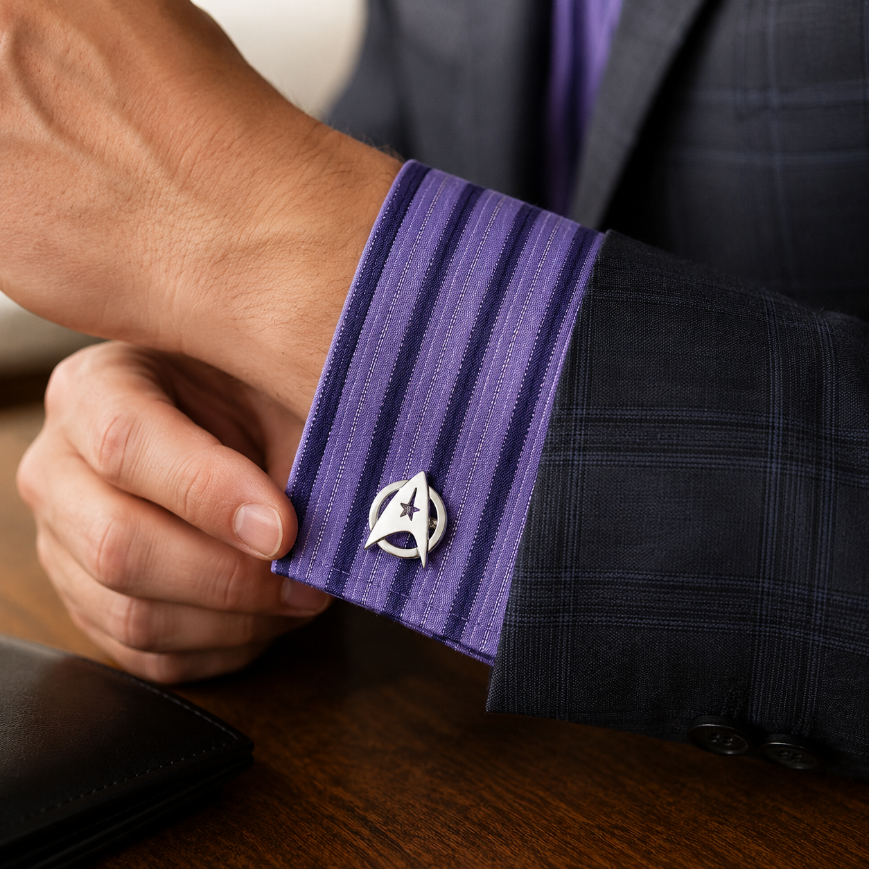 Close-up of a person adjusting a purple cufflink on a suit sleeve. Silver Starfleet Command cufflinks featuring a polished silver delta emblem design on a white background, perfect for science fiction fans and formal wear enthusiasts.