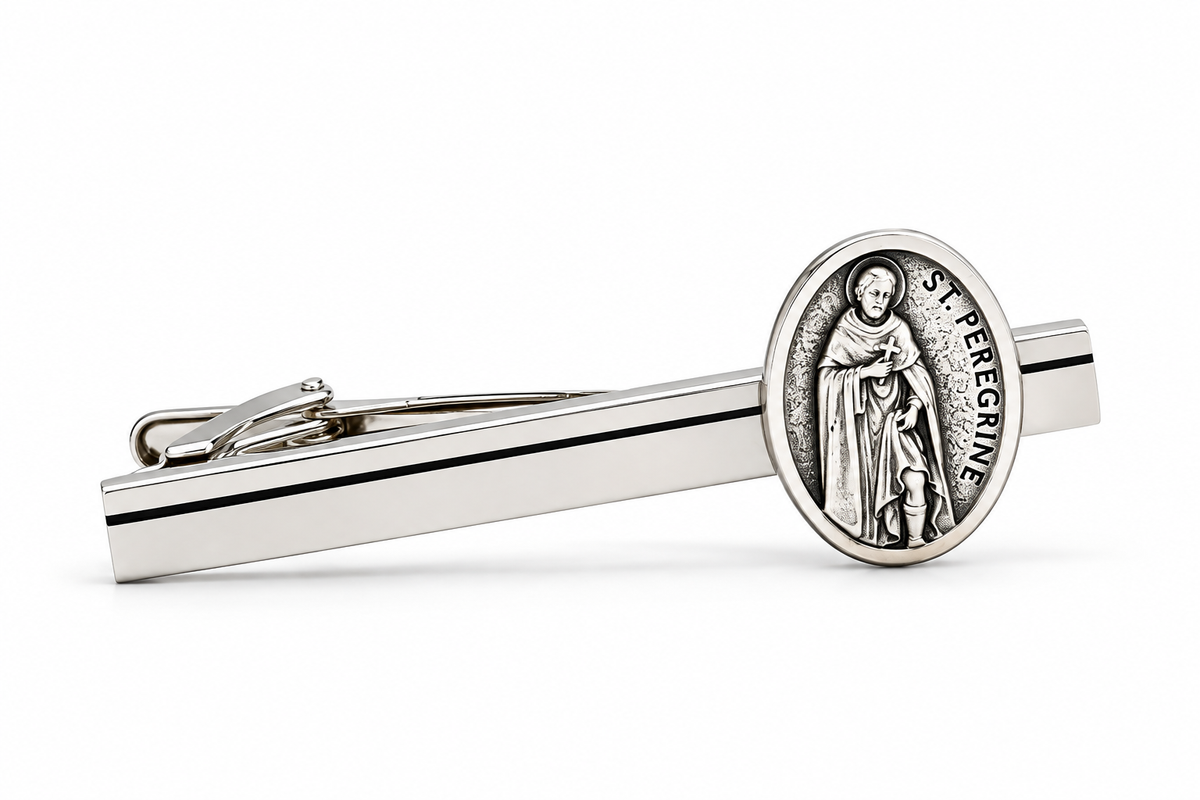 A silver-toned tie bar featuring an oval Saint Peregrine medal on the tip, displayed on a clean white background.