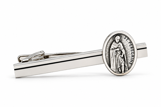 A silver-toned tie bar featuring an oval Saint Peregrine medal on the tip, displayed on a clean white background.