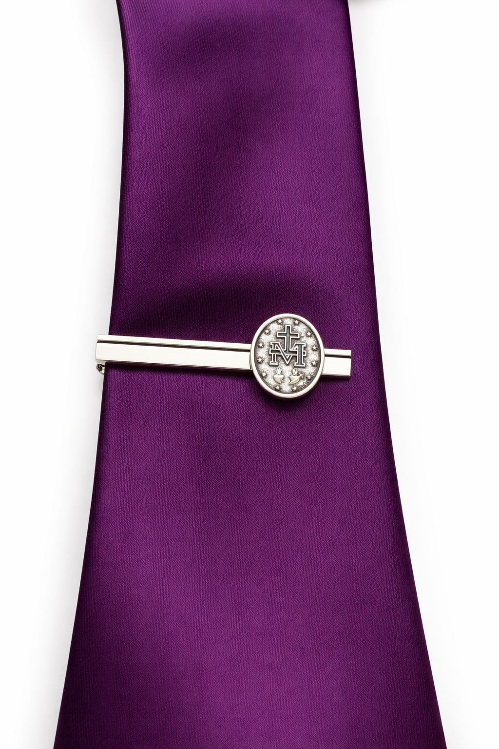 Silver tie clip on a purple tie against a white background