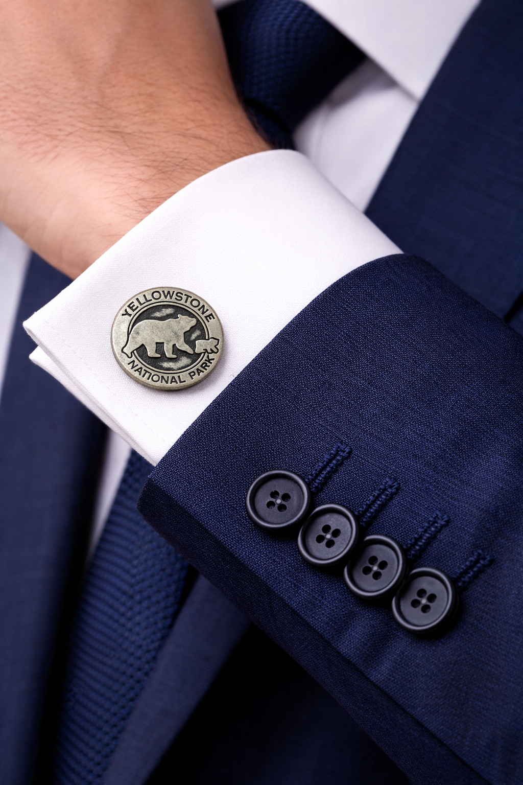 Close-up of a navy suit with Yellowstone National Park cufflinks.