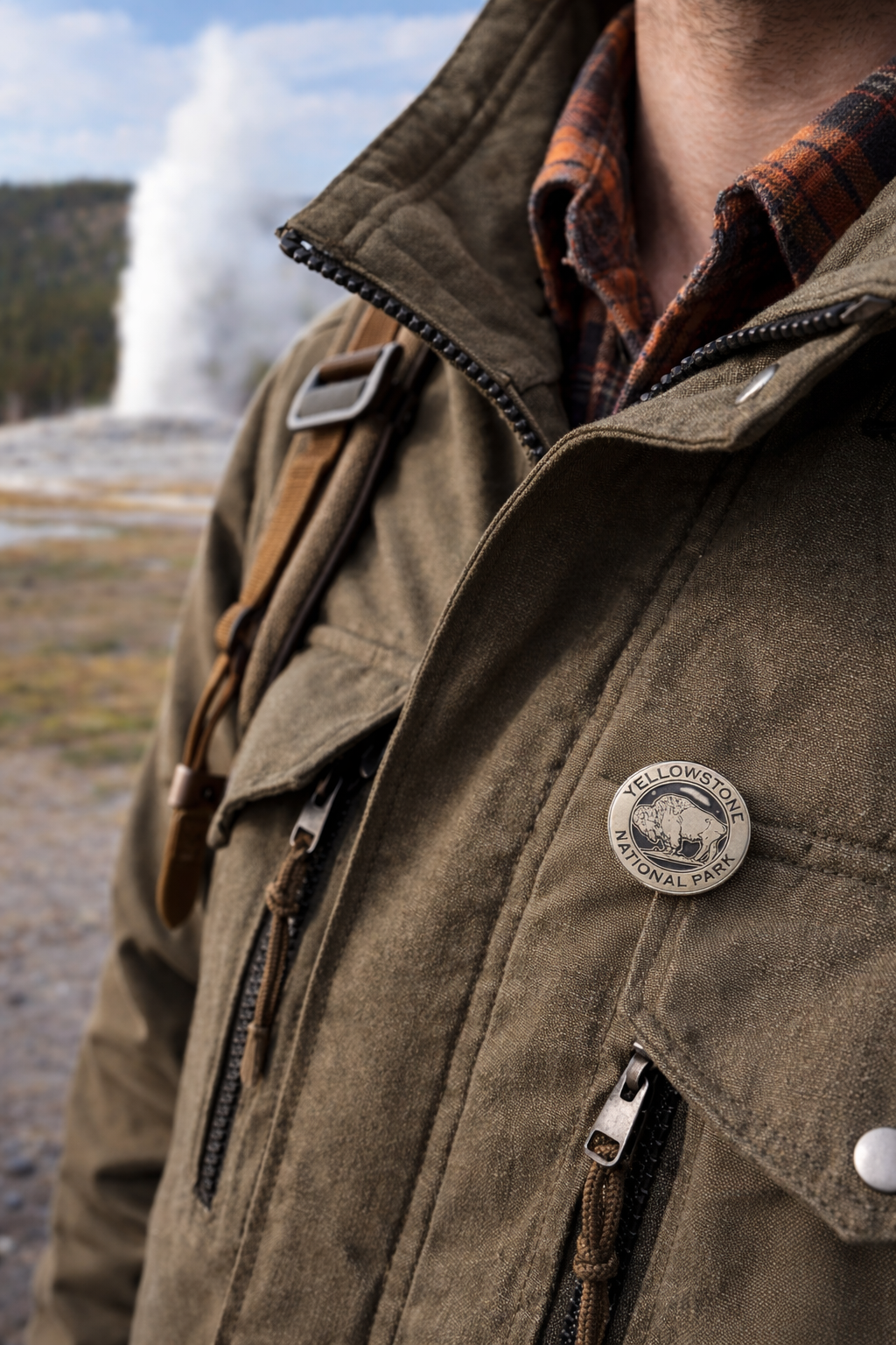 Brown jacket with Yellowstone National Park logo pin in a natural setting