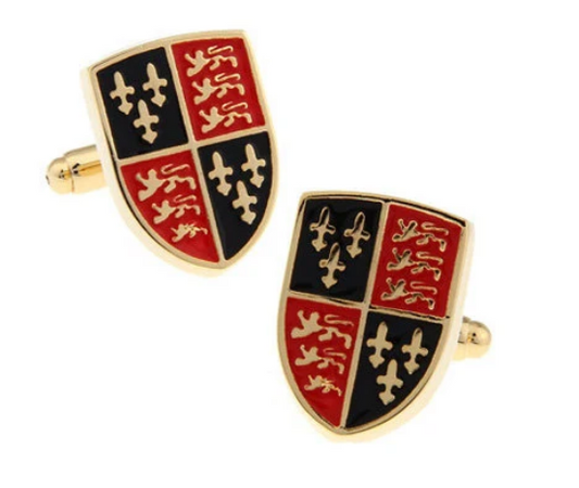 Shield-shaped cufflinks with red, black, and gold design on a white background