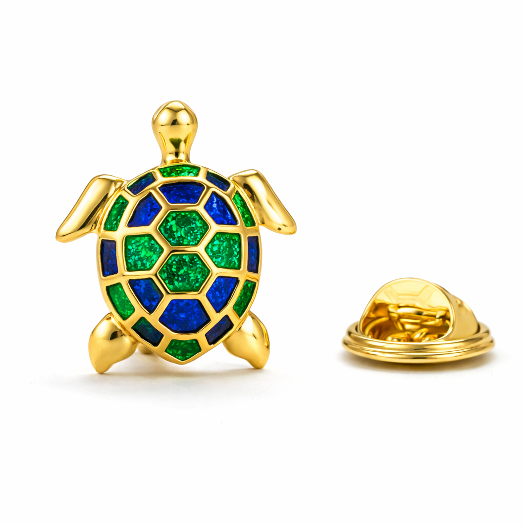 High-detail overhead view of a gold-plated sea turtle lapel pin with emerald green and royal blue enamel shell, shown next to its matching gold butterfly clutch backing on a crisp white background.