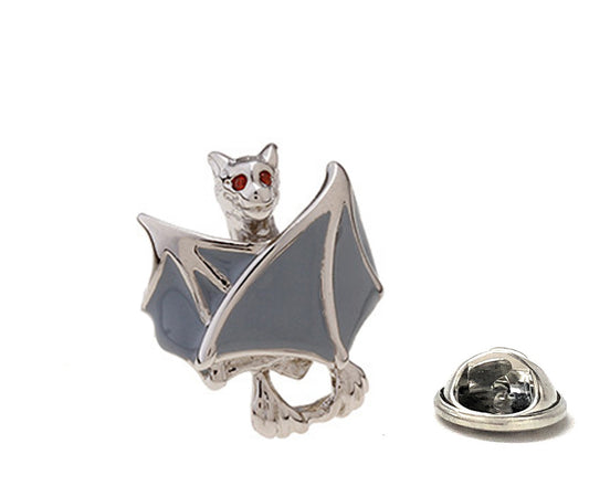 Bat-shaped lapel pin with gray wings and red eyes on a white background