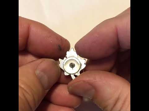 Red maple leaf lapel pin with silver outline and butterfly clasp displayed on white background