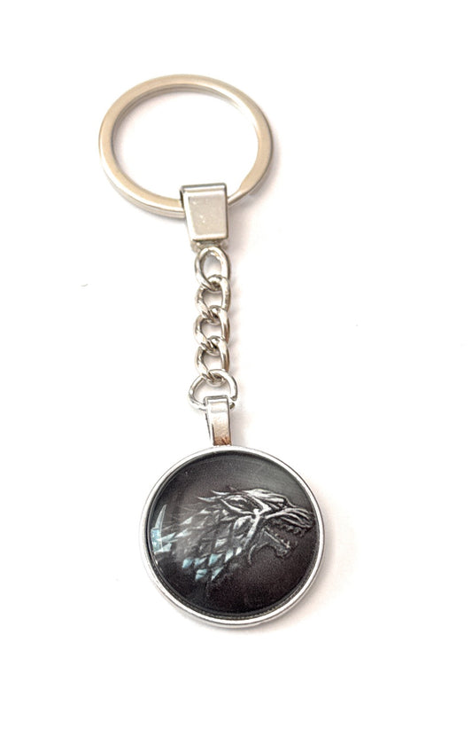 Keychain with a circular pendant featuring a wolf design on a white background